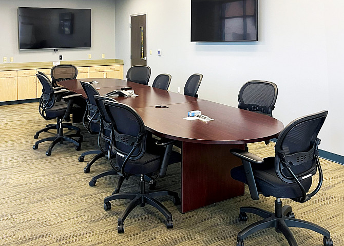 Photo of the Conference Room with 11 chairs around a conference table