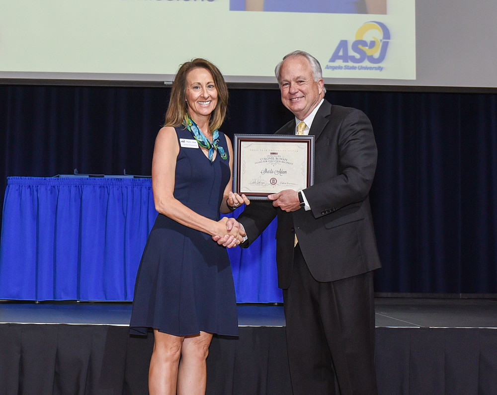 Sharla Adam receiving the 2016-17 Chancellor's Colonel Rowan Award for Execution from university president Dr. Brian May.