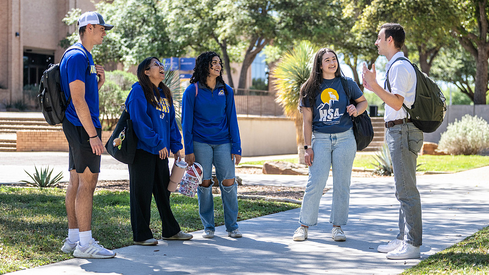 A group of ASU honors students standing outside talking.