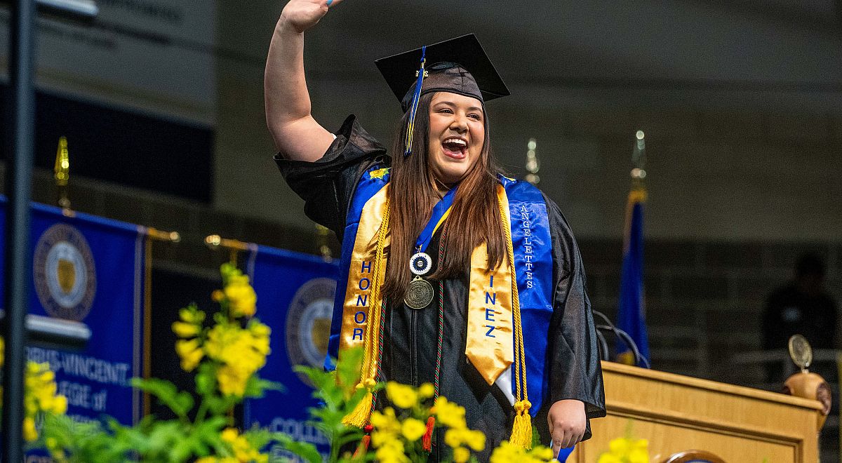 An ASU graduate raising her hand during the College of Science and Engineering graduation