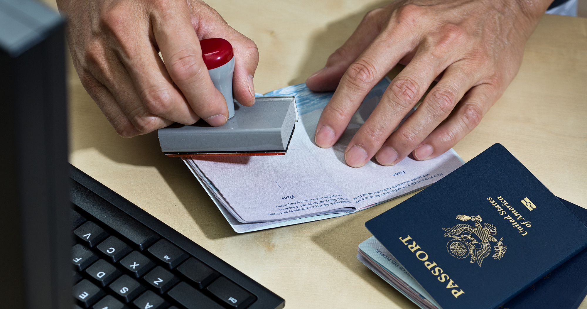 A U.S. border Security agent, inspecting passport at the U.S. customs and Border Protection station.