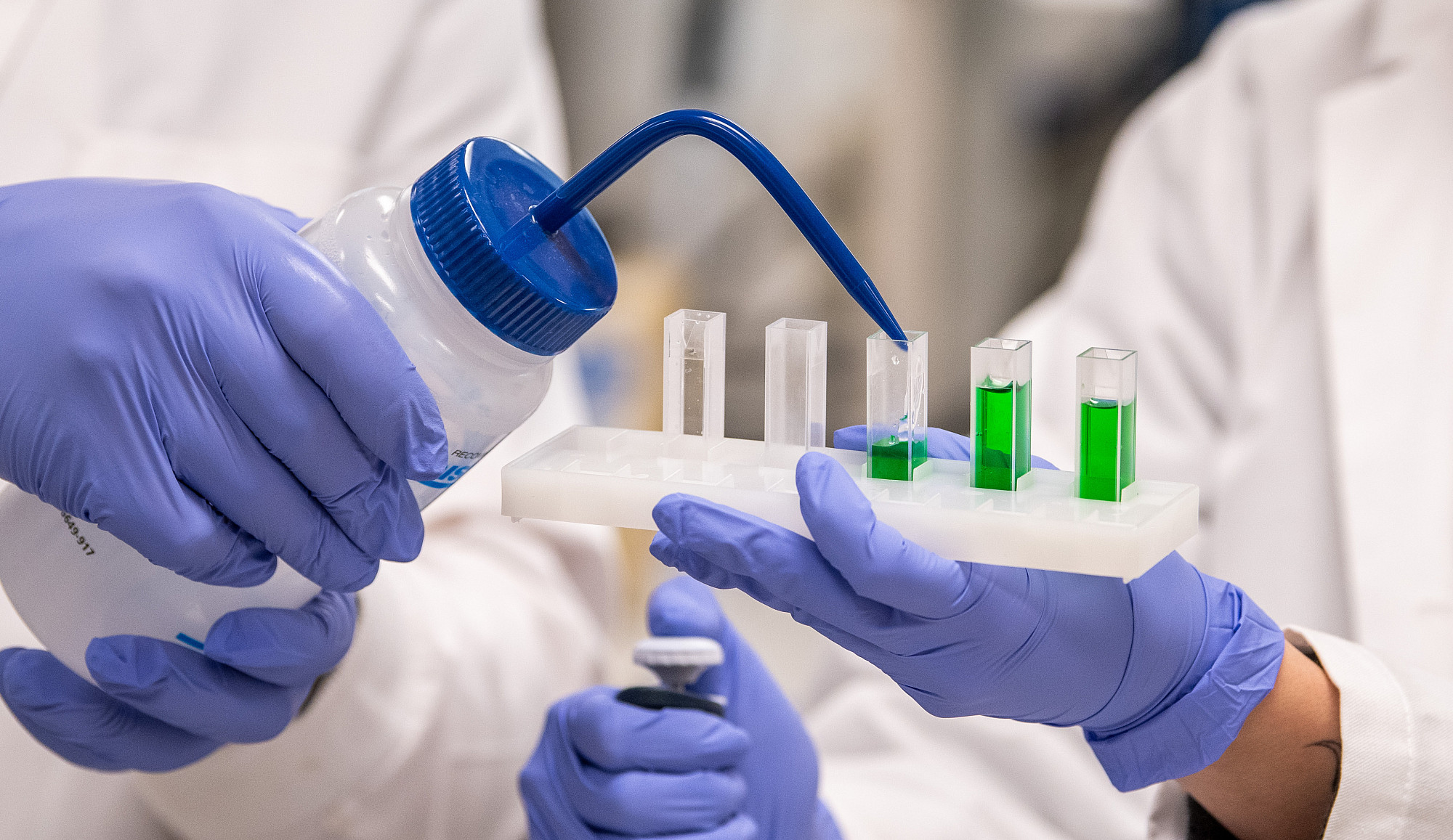 Vials being filled with a green liquid