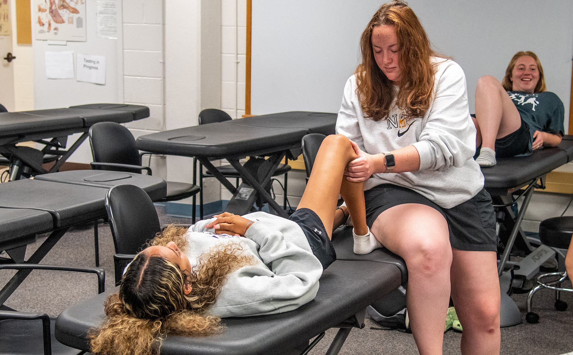 A student performing an exercise on another students calf