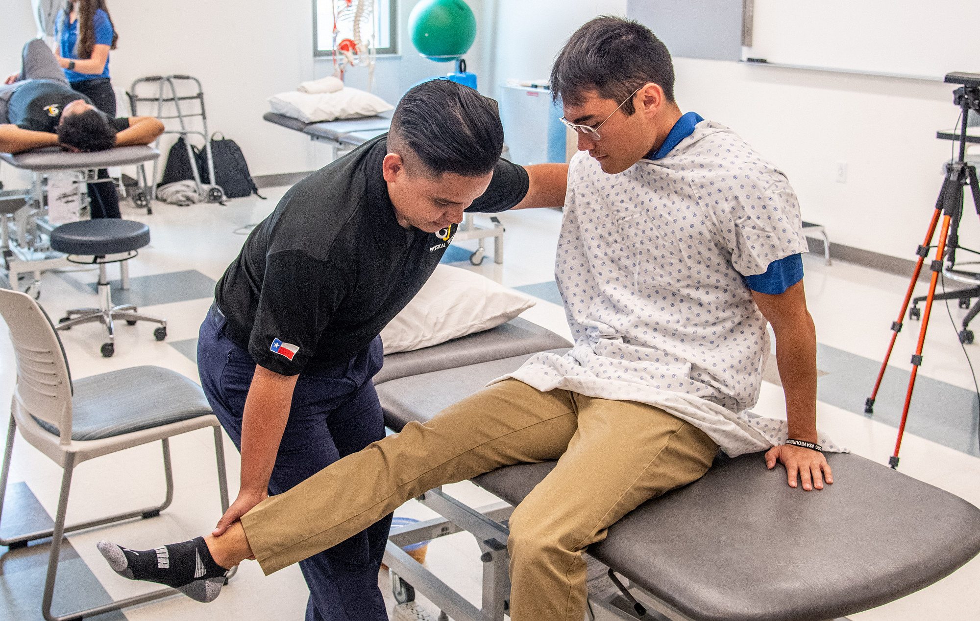 Angelo State Physical therapy student examining a patient's leg on a table