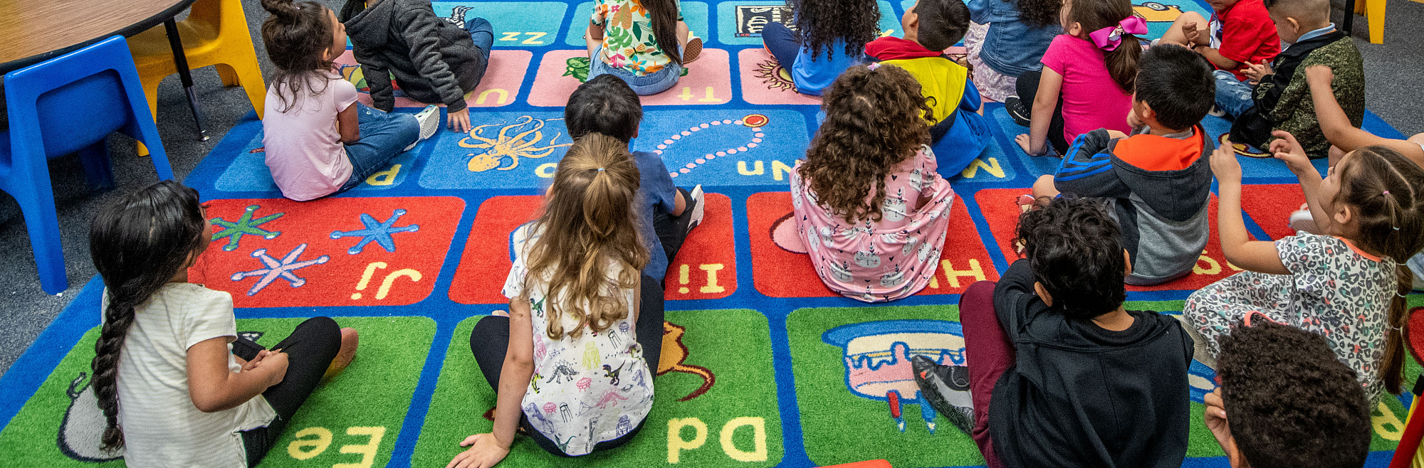 A student teacher working with children in a classroom