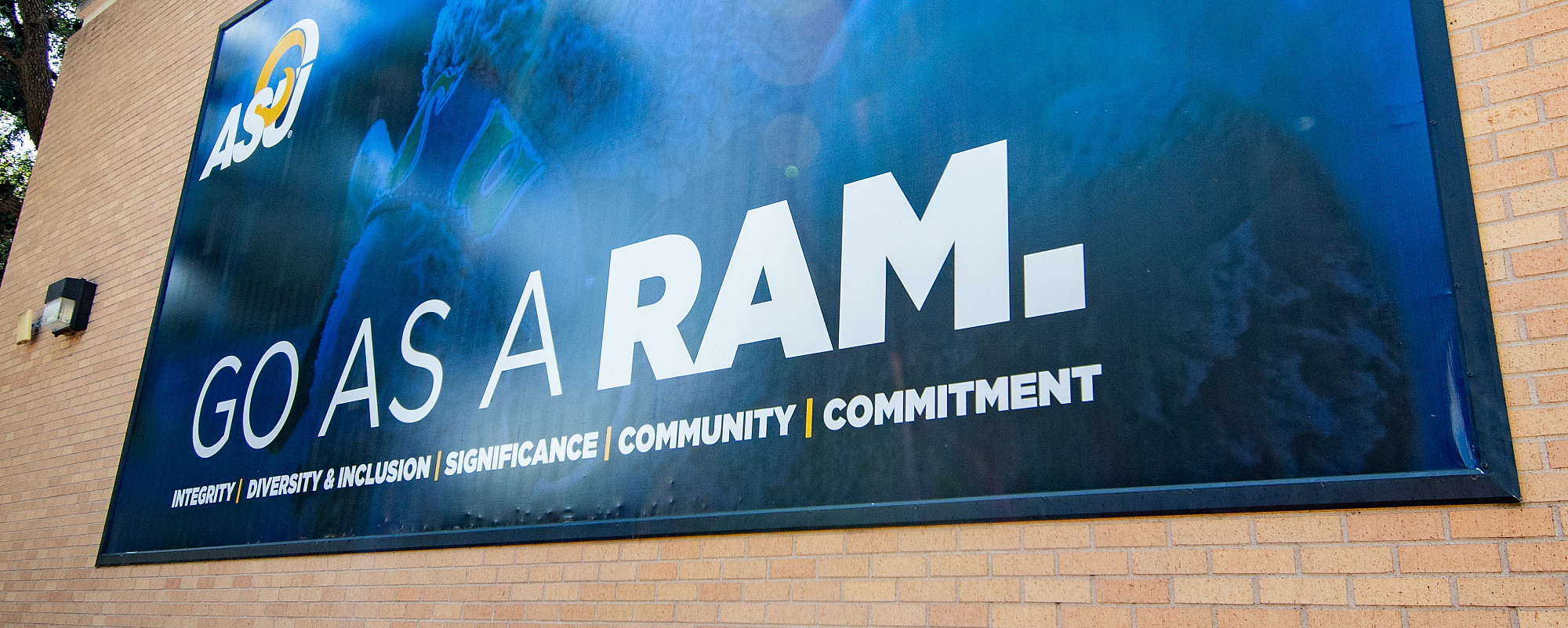 A big blue banner that says Go As A Ram on the side of a building.