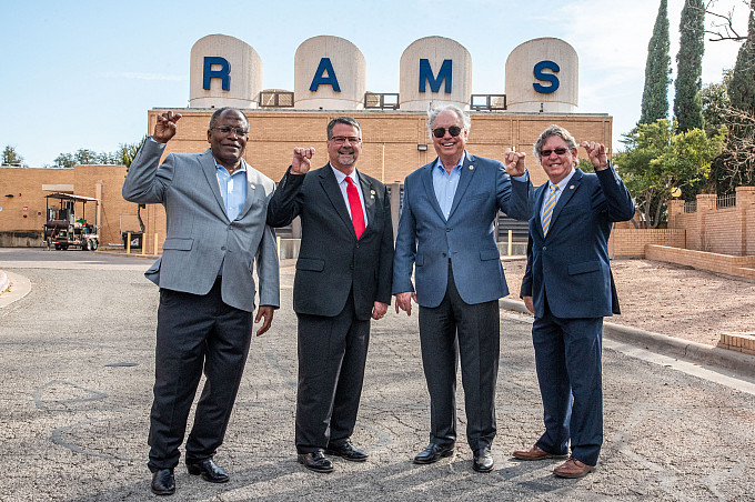 Men smiling holding up the ram hand.