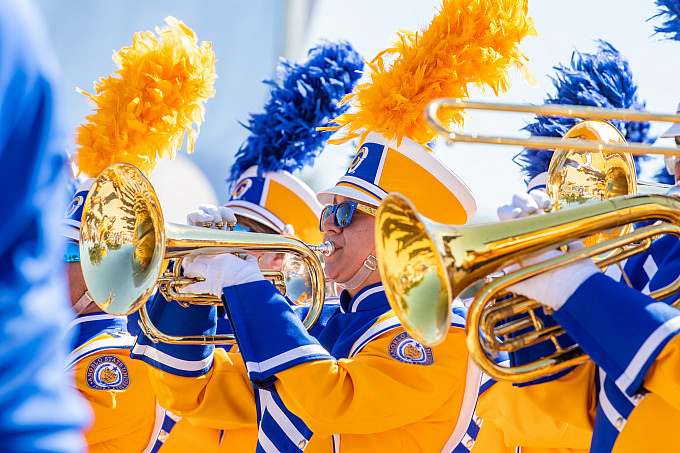 Members of Ram Band stand in a row and play their instruments.