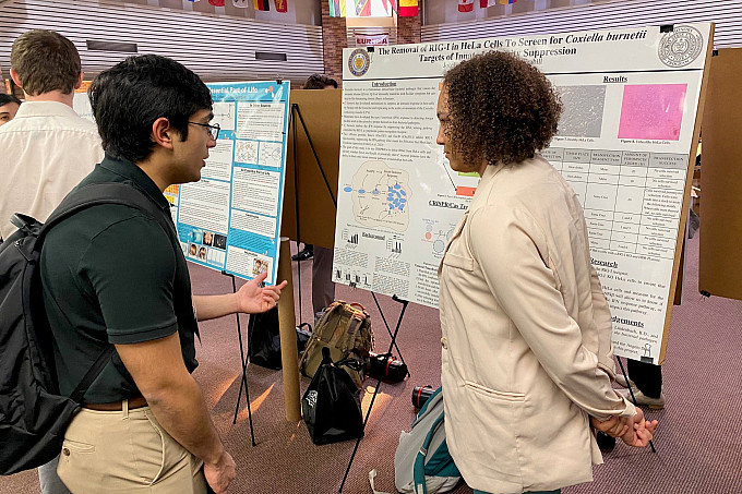 An ASU Honors student discussing her research with another Honors student.