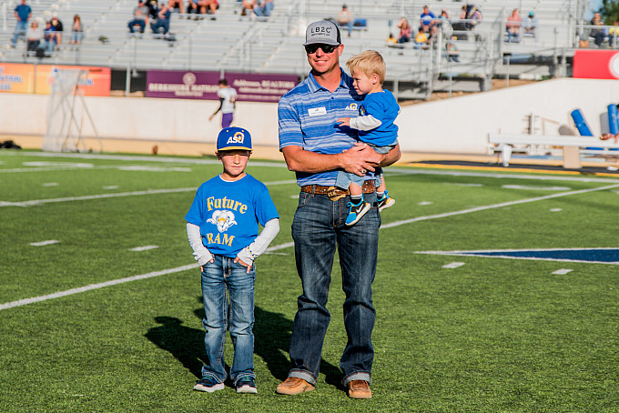 Homecoming honorees with his kids on the football field