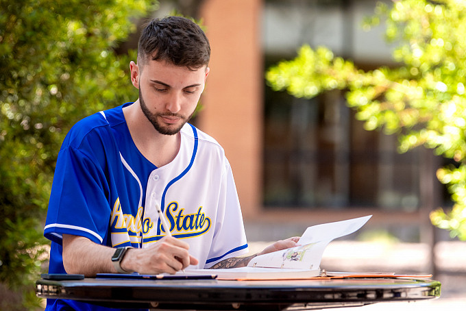 A student studying outdoors on campus