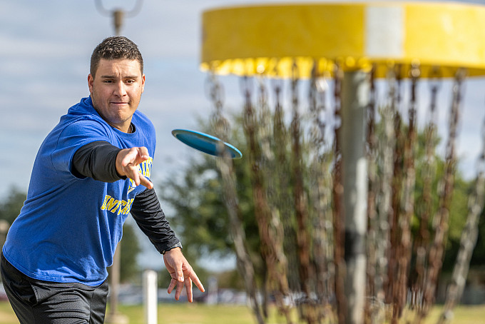Angelo State student playing a round of disc golf.