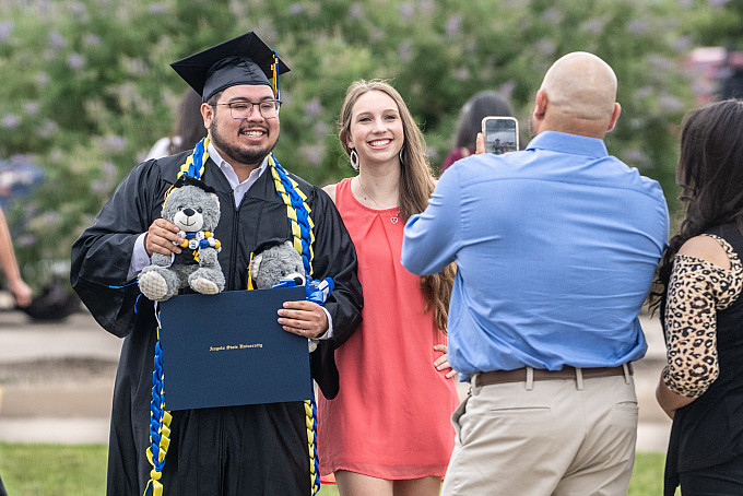 An ASU graduate taking a photo with a friend after the College of Science and Engineering graduation ceremony