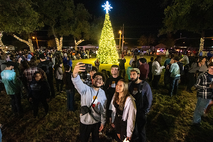 Angelo State students talking a selfie in front of the Christmas Tree