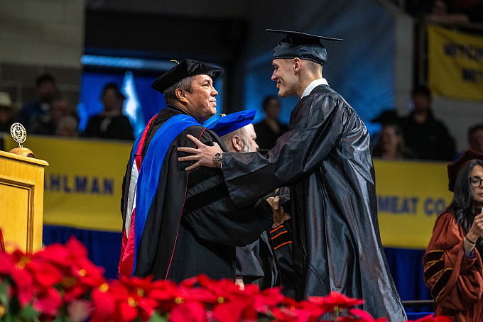An ASU graduate shaking hands with a professor during the Fall 2023 Commencement