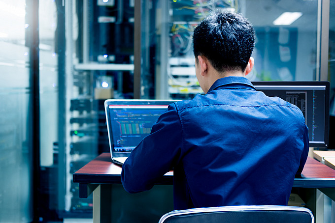 A young IT engineer working in a server room