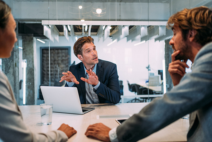 Group of business professionals talking in the office.