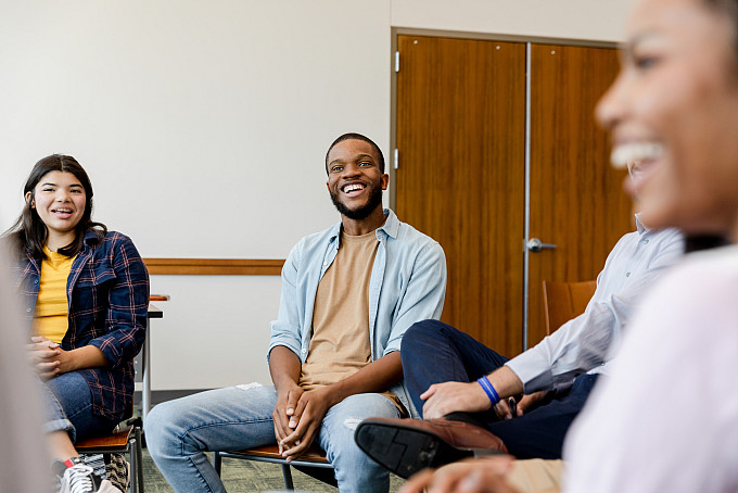A group of psychology students sit near each other to talk about their class.