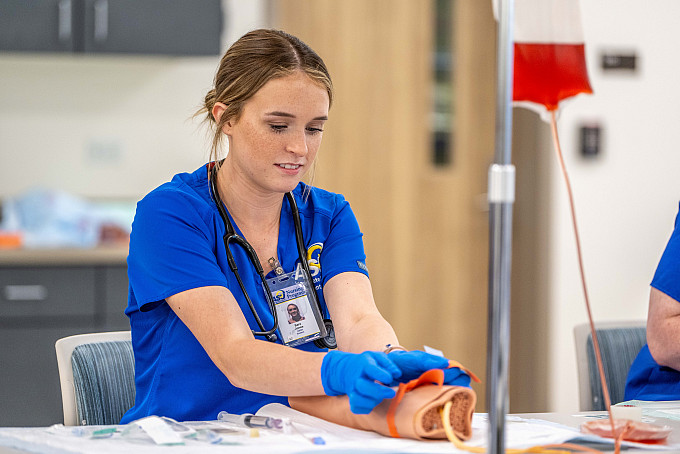 ASU nursing student practicing  how to take blood from the arm.