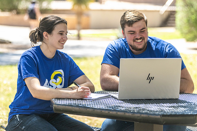 Two ASU honors students working on their homework outside.
