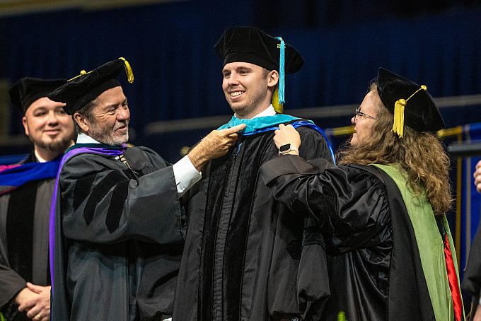 An ASU graduate smiling during the Archer College of Health and Human Services graduation