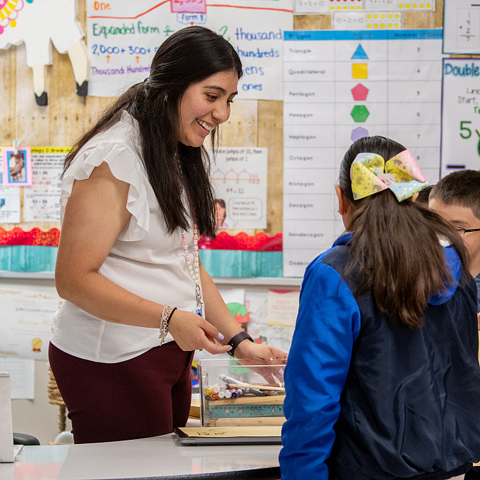 A student teacher working with children in a classroom