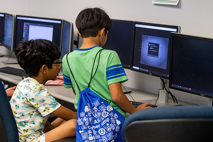 Two middle school students working on computers during CyberCamp@ASU