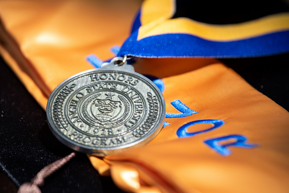Close up photo of a Honors medal and stole