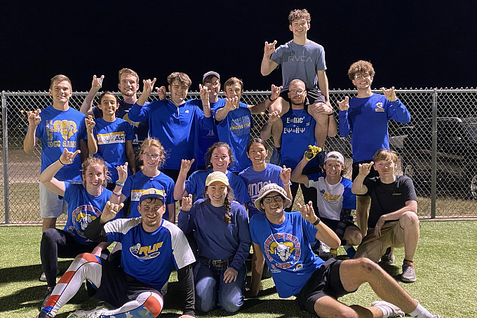 Honors students holding up the ram hand on a sports field